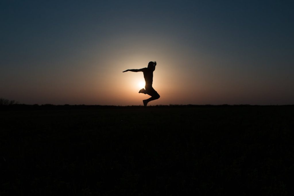 silhouette-photo-of-jumping-person-during-twilight-hour-1228396 Dynamic silhouette jump against a vibrant sunset sky, symbolizing freedom and joy.