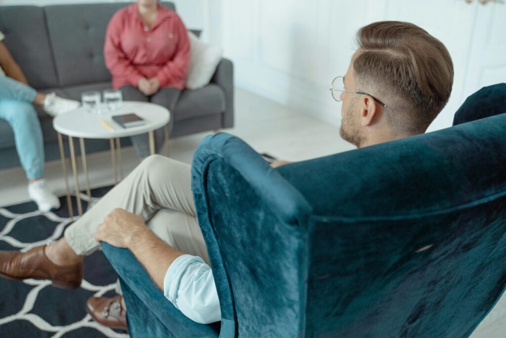 pexels-photo-5336890-5336890 A man having a counseling session with a therapist in a modern office setting.